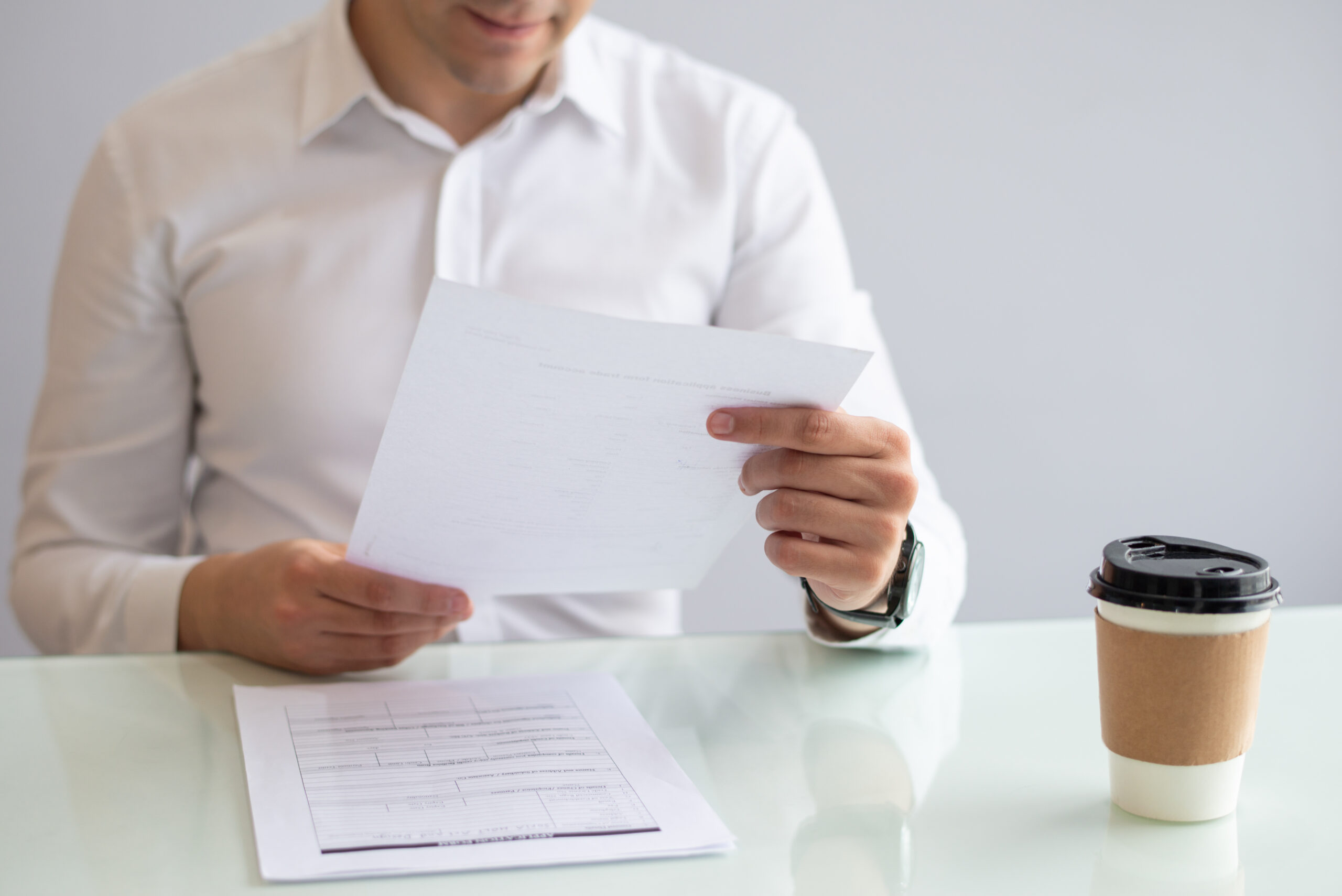 Close-up of smiling young businessman looking at document